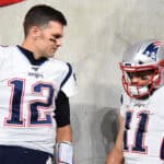 BALTIMORE, MARYLAND - NOVEMBER 03: Quarterback Tom Brady #12 of the New England Patriots looks on with teammate wide receiver Julian Edelman #11 before playing against the Baltimore Ravens at M&T Bank Stadium on November 3, 2019 in Baltimore, Maryland.